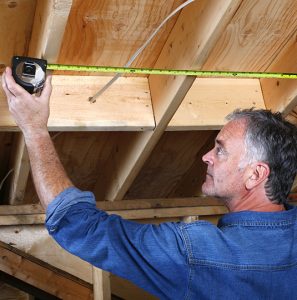 Renovation Contractor Measuring Ceiling