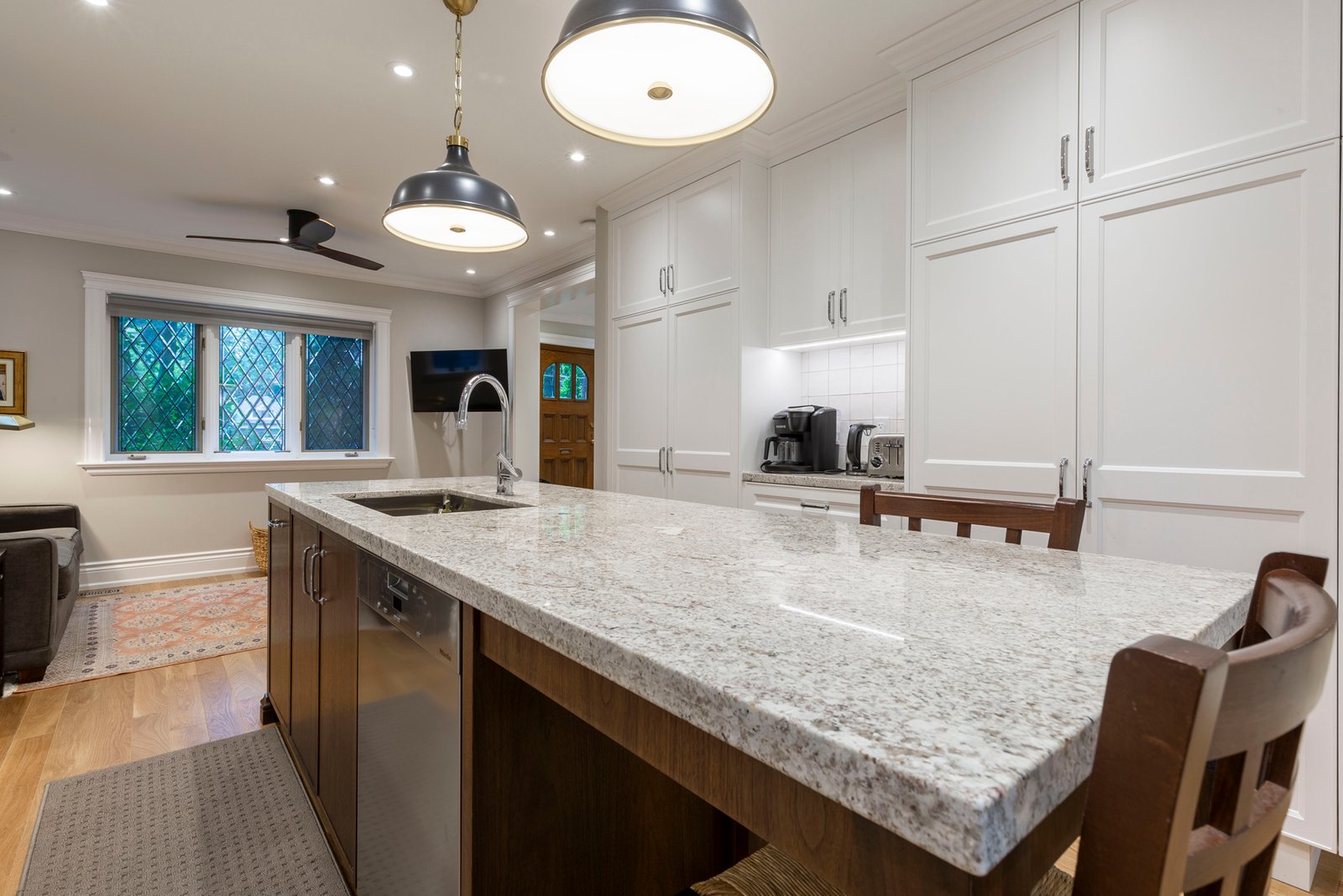 White kitchen with granite island and leaded glass window