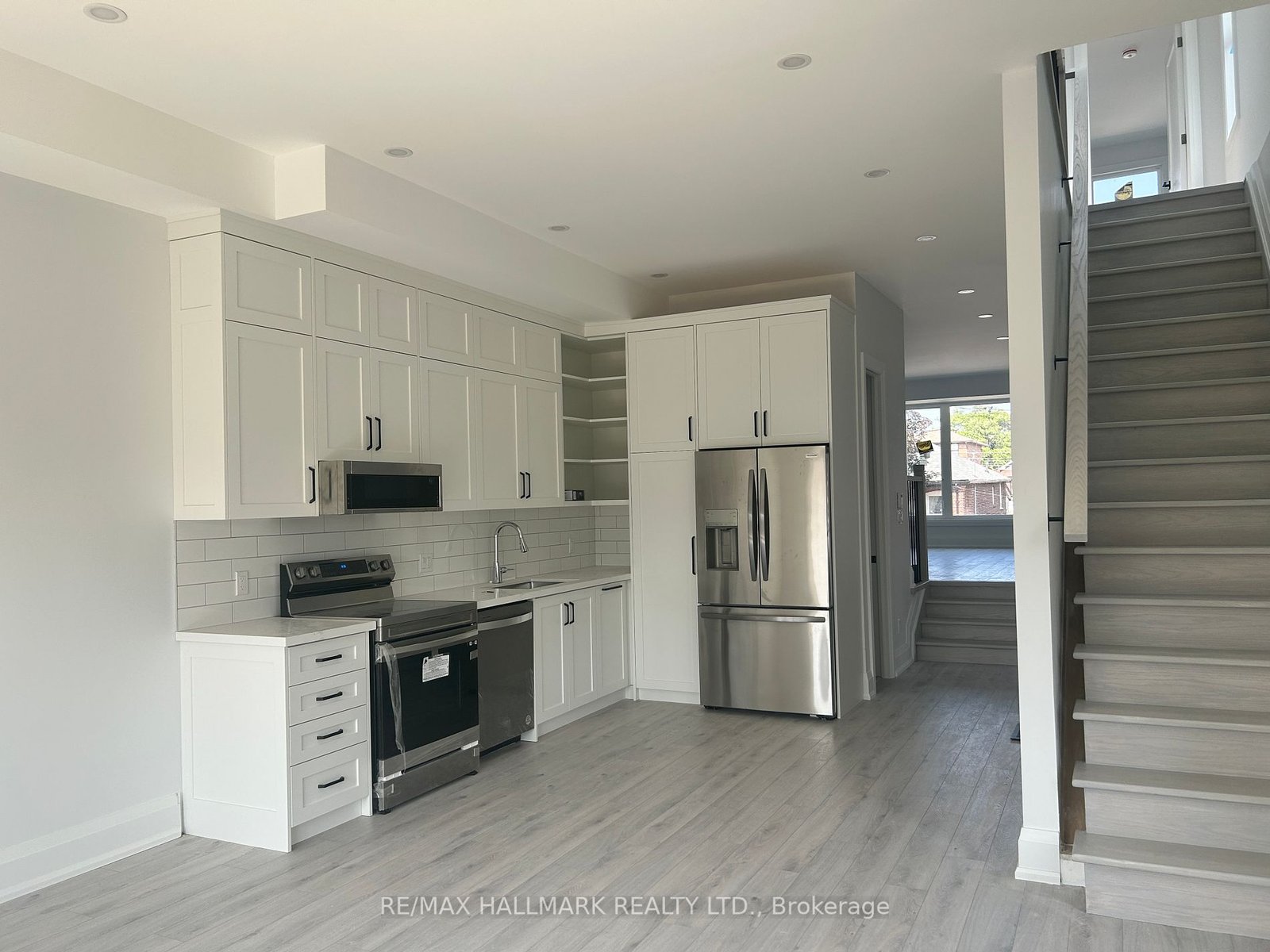 Kitchen with new appliances beside the staircase