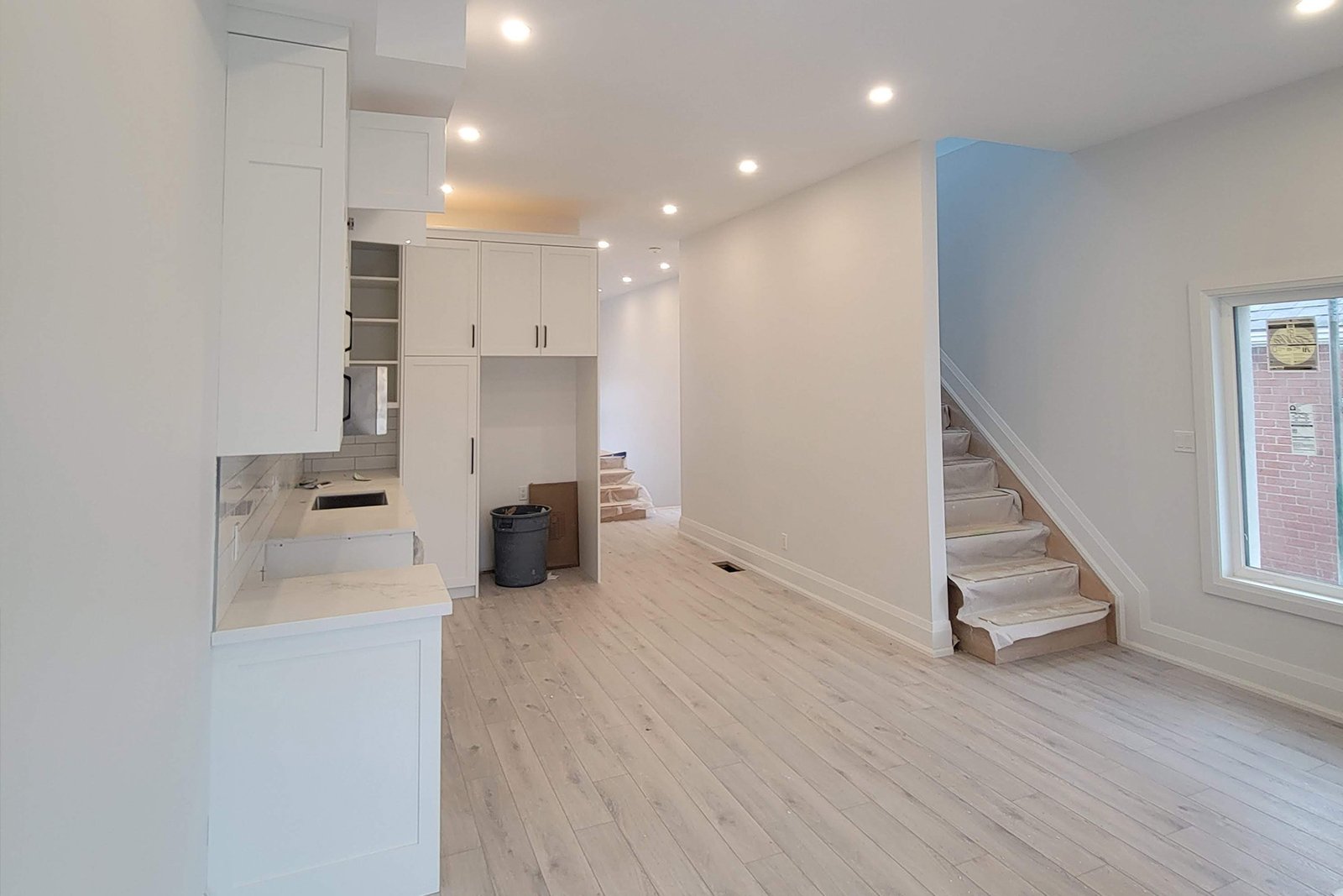 Main floor with white kitchen and new staircase