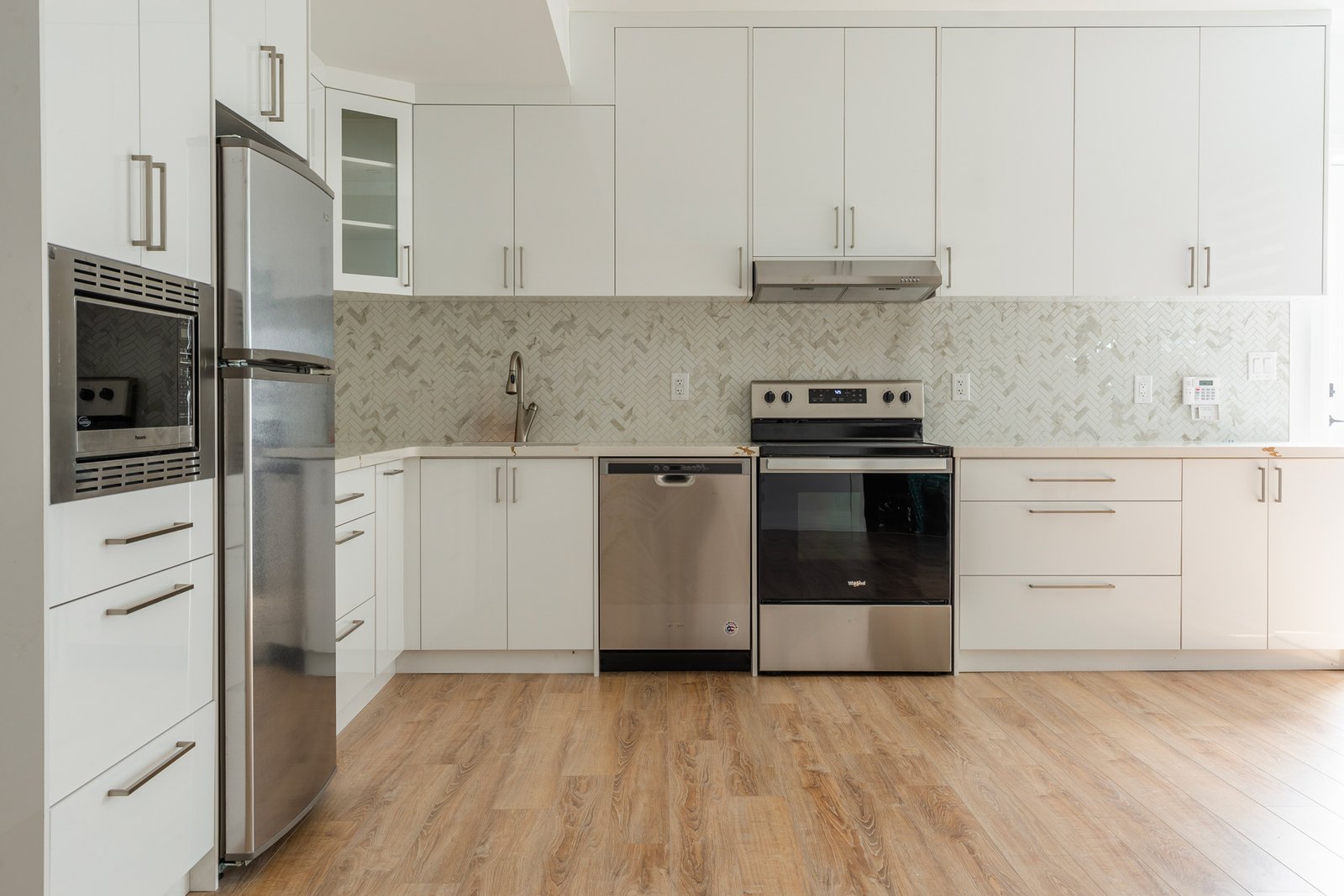 Second kitchen with white cabinets and stainless appliances