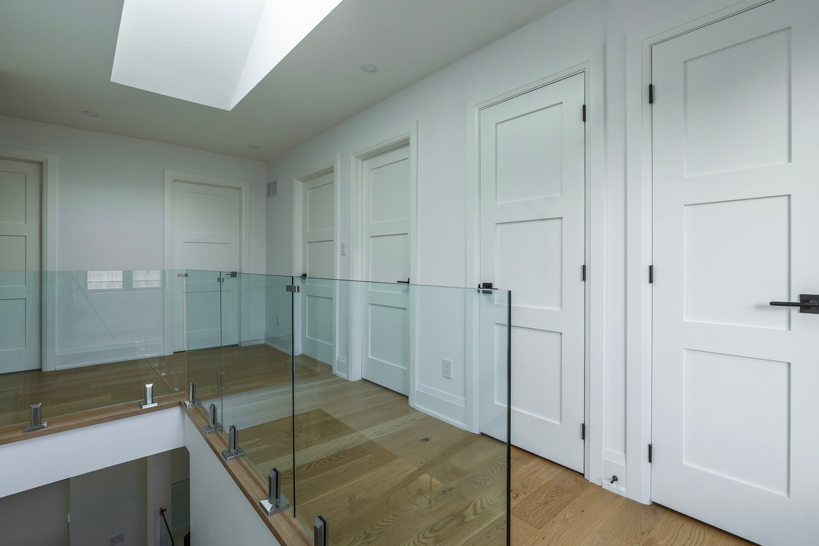 Upper hallway with skylight and glass railing