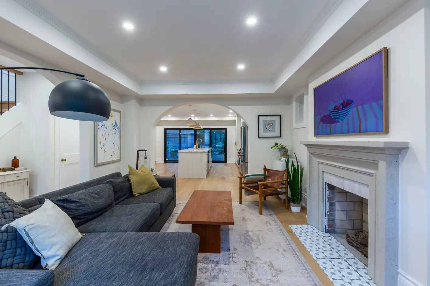 Living room with white mantel fireplace and arched doorway