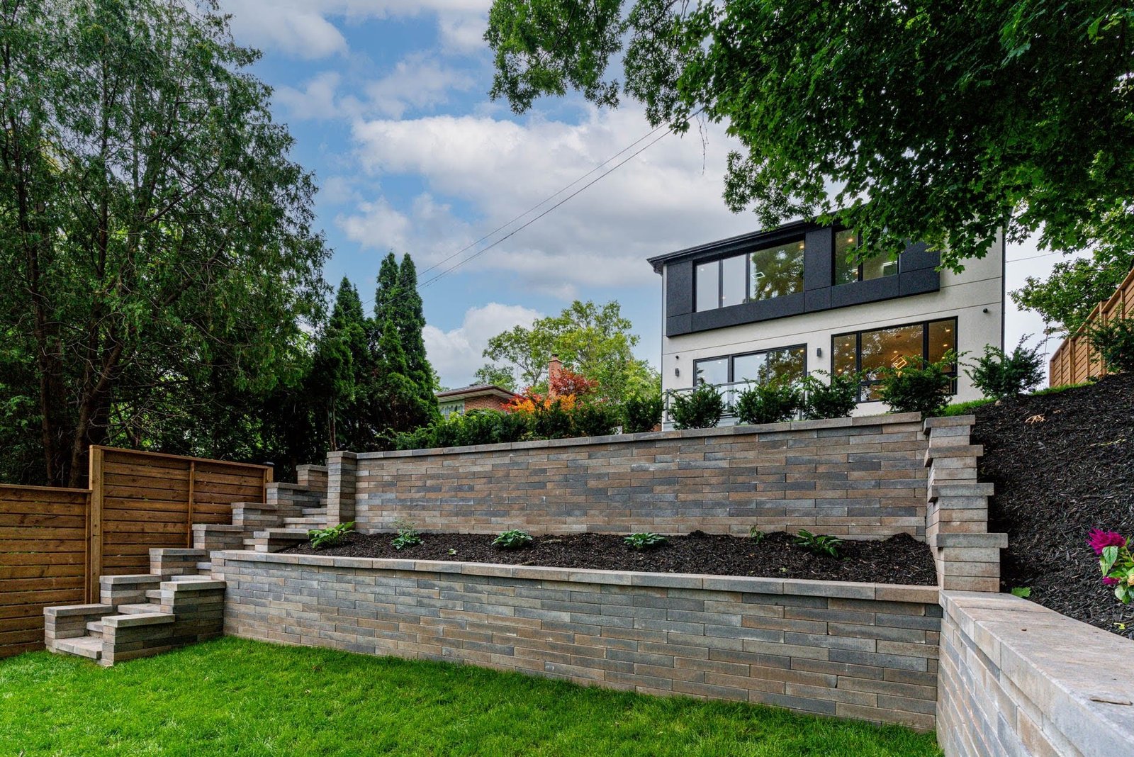 Rear exterior with stone retaining wall landscaping