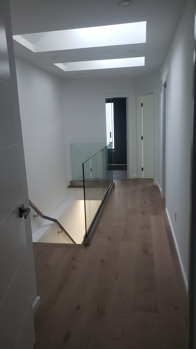 Upper hallway with skylights and glass railing