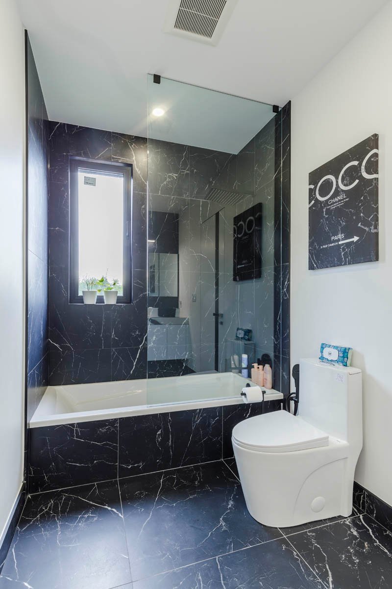 Bathroom with black marble tub and tile surround
