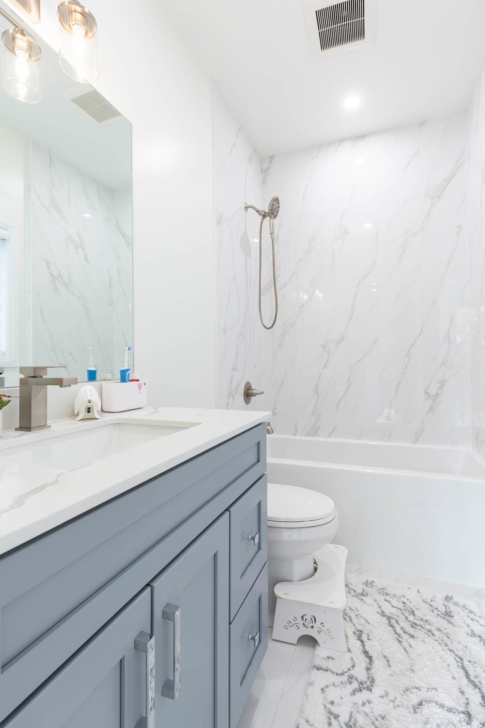 Bathroom with grey vanity and tub