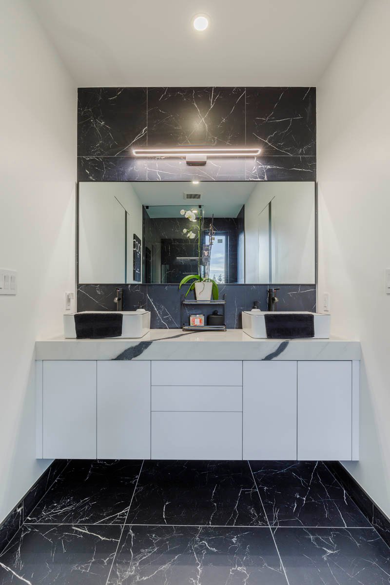 Bathroom with white designer vanity and black marble floor