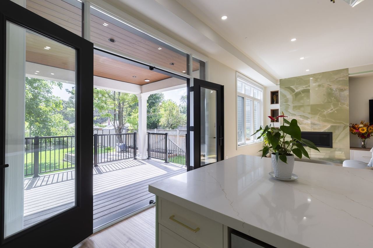 Covered patio and deck viewed through kitchen walkout doors