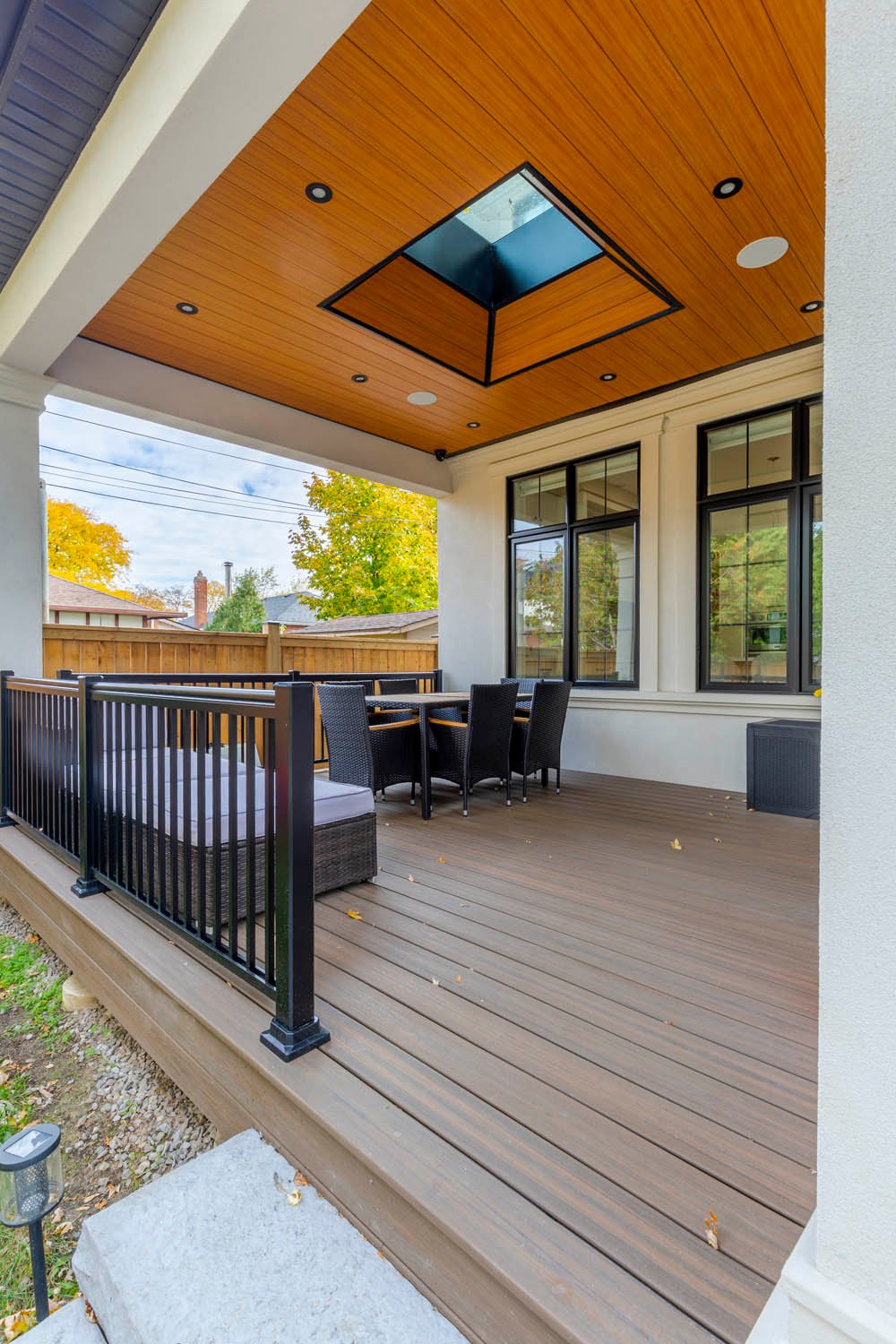 Covered patio with wood ceiling, skylight and rear deck