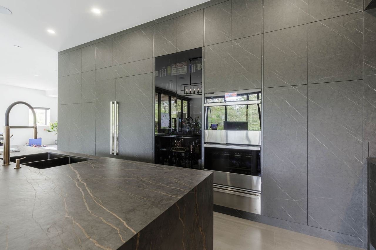 European style kitchen with dark stone island and integrated appliances