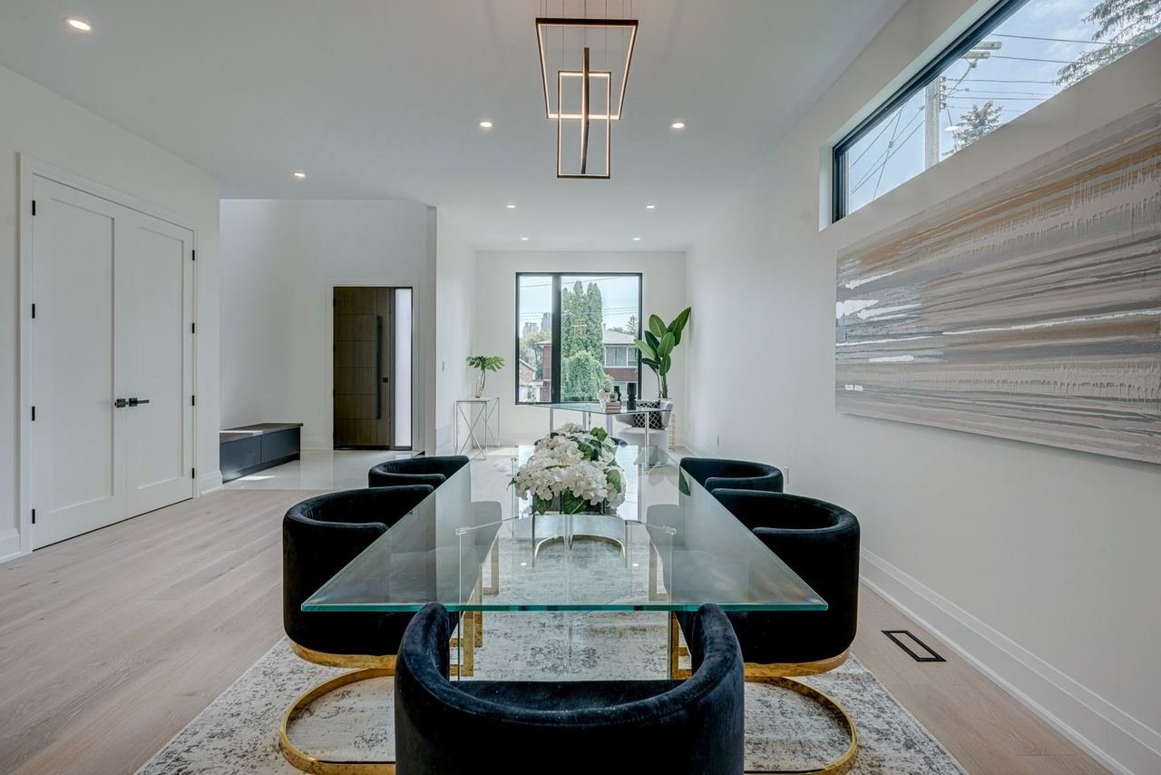Modern dining room with black accents and glass table