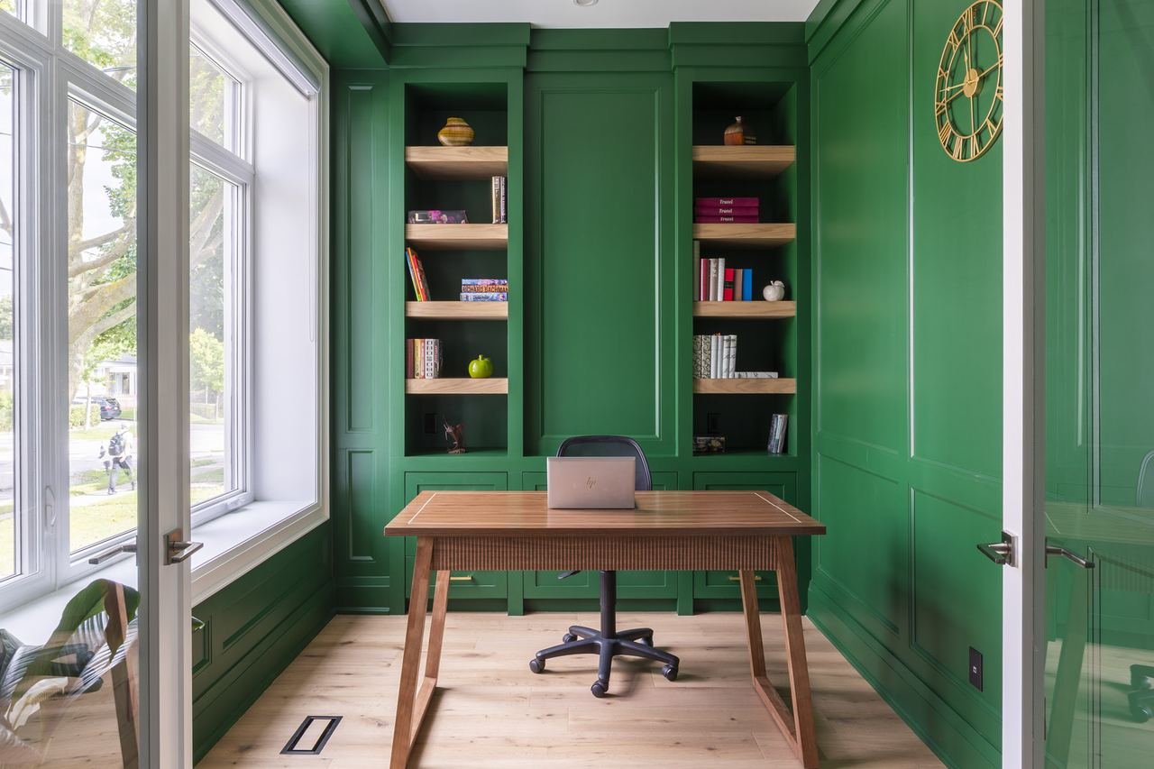 Home office with green built-in cabinetry and shelving