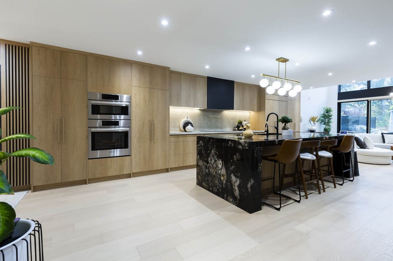 Kitchen with black granite waterfall island and wood cabinetry