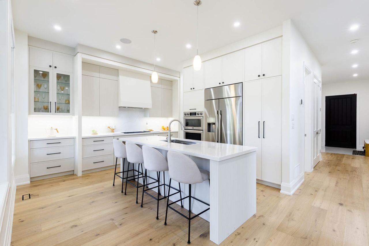 Kitchen with white cabinetry, large island and seating