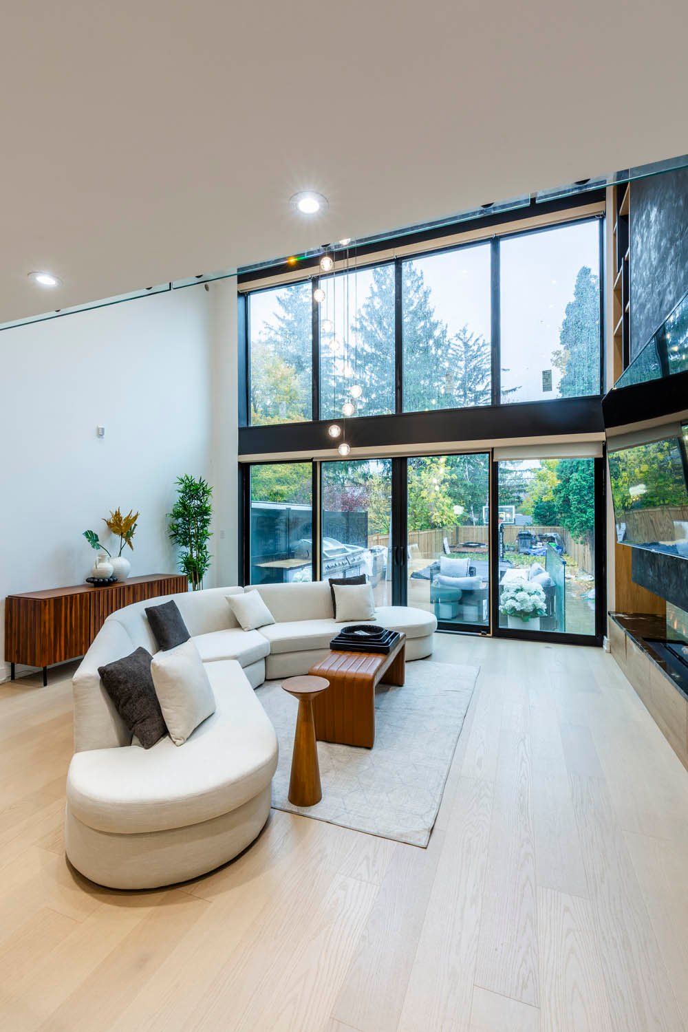 Living room with curved sofa and full height windows