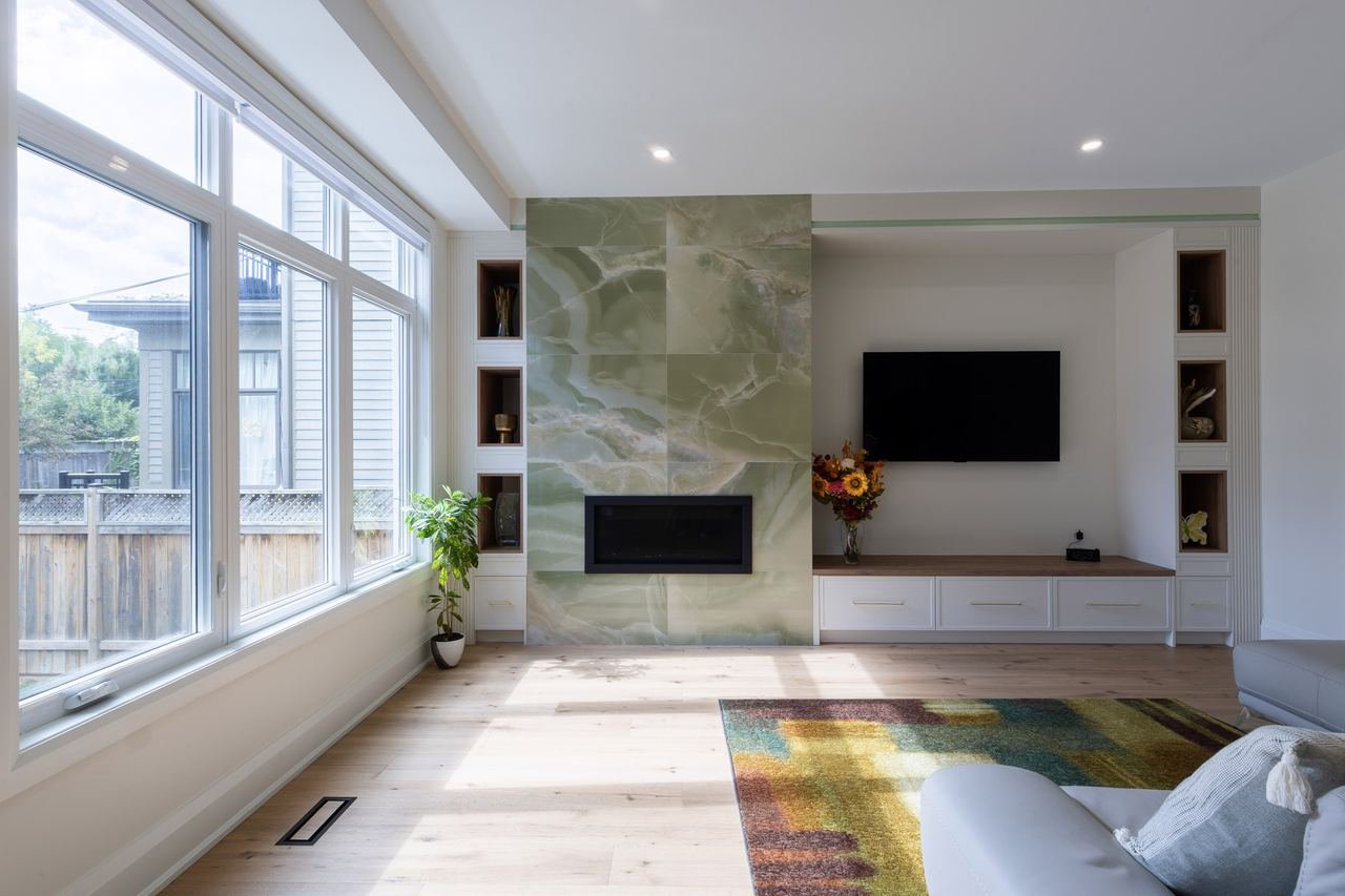 Living room with green onyx fireplace feature wall and built-in shelving
