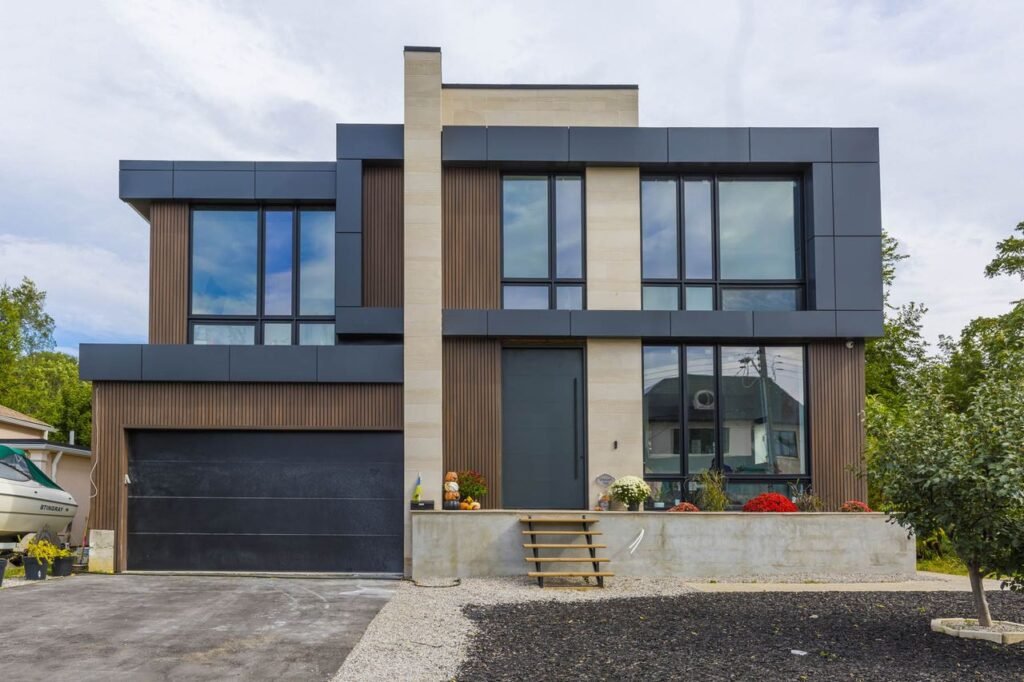 Modern design-build home front elevation with wood and black panels, double car garage — Donnavale Dr