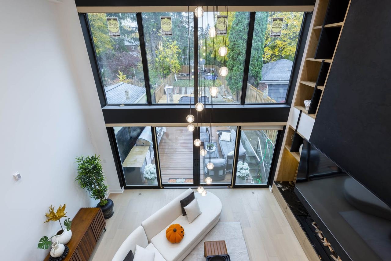 Open to above living space with full height windows and black feature wall in the Balliol St complete rebuild