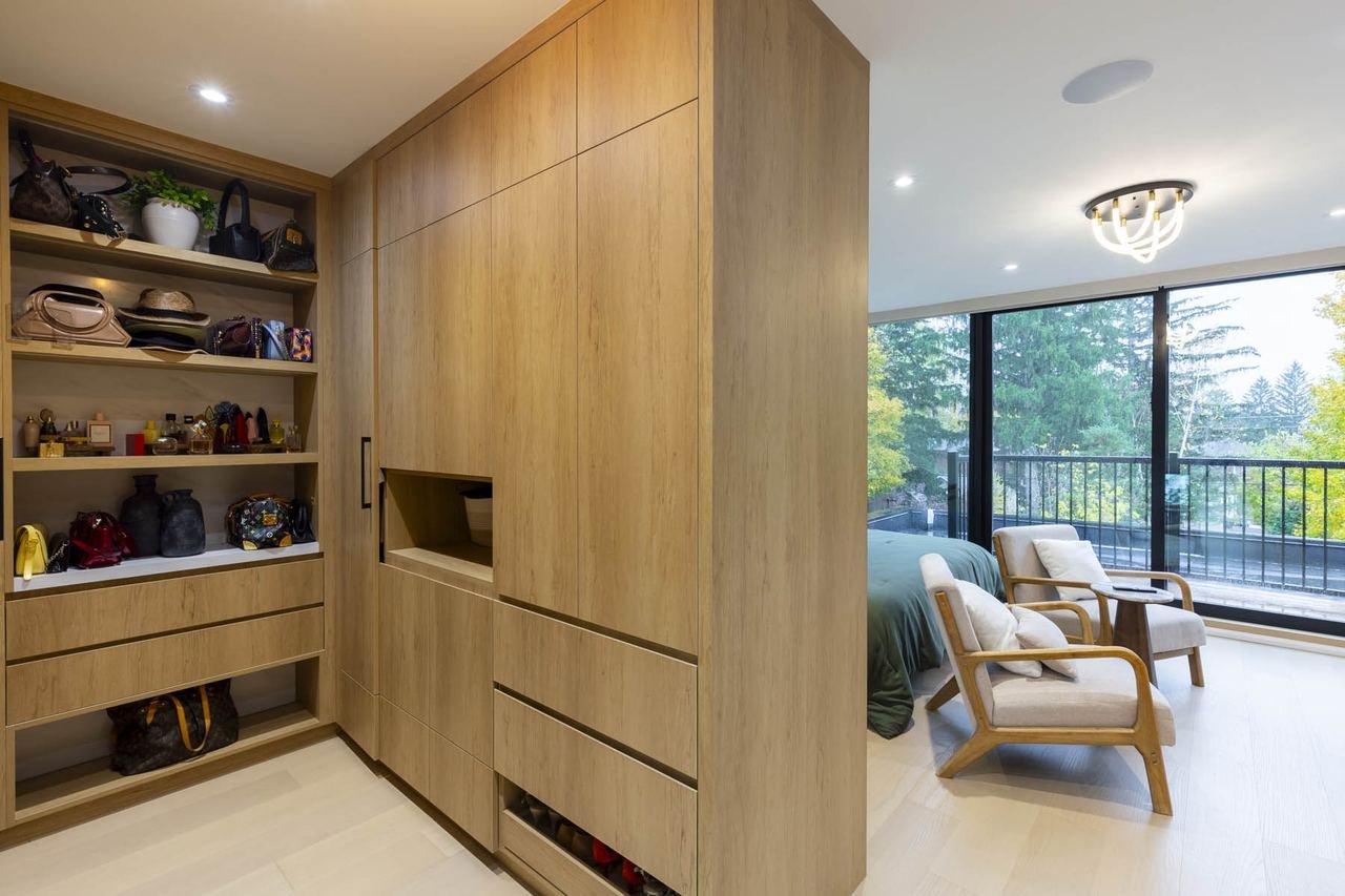 Primary walk-in closet and dressing room with custom wood cabinetry