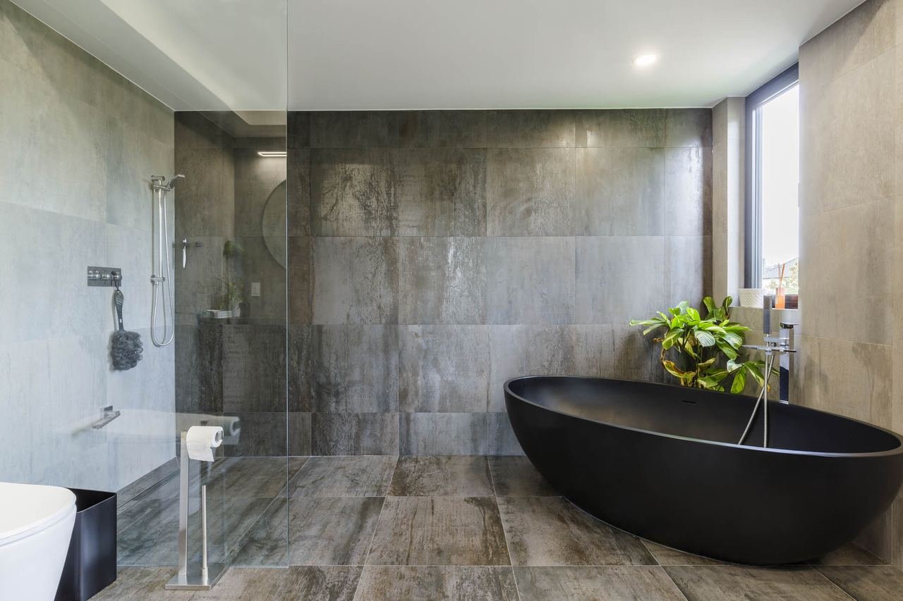 Primary ensuite with black freestanding tub and walk-in shower