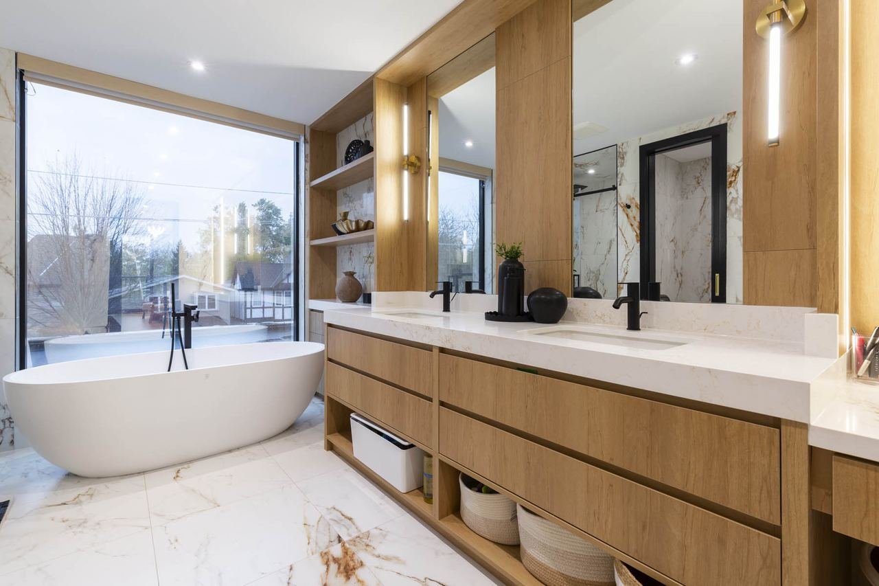 Primary ensuite with freestanding tub and double vanity in marble