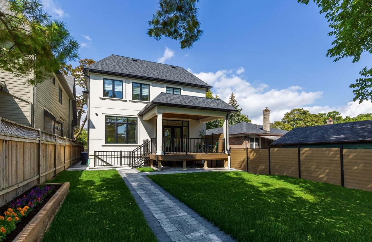 Rear exterior with covered patio, deck and landscaped backyard