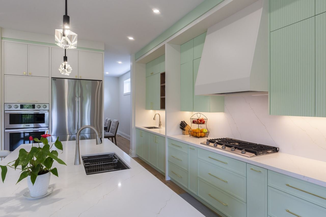 Sage green kitchen with range and stainless steel appliances