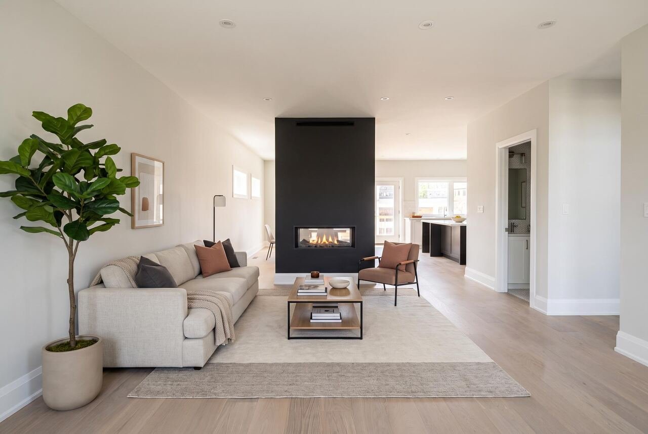 Living room with double-sided gas fireplace dividing the open concept main floor