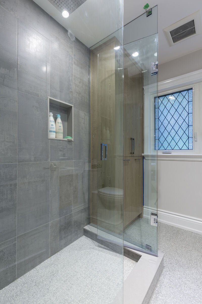 Renovated ensuite bathroom with glass walk-in shower and patterned tile