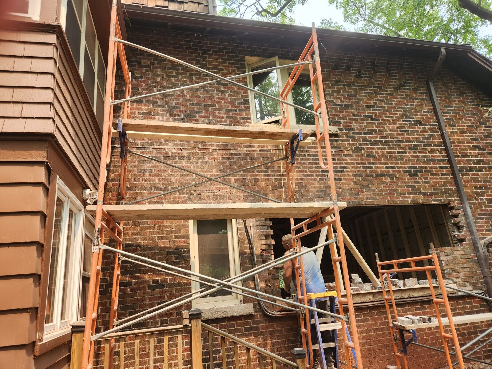Masonry work on scaffolding during exterior brick alterations