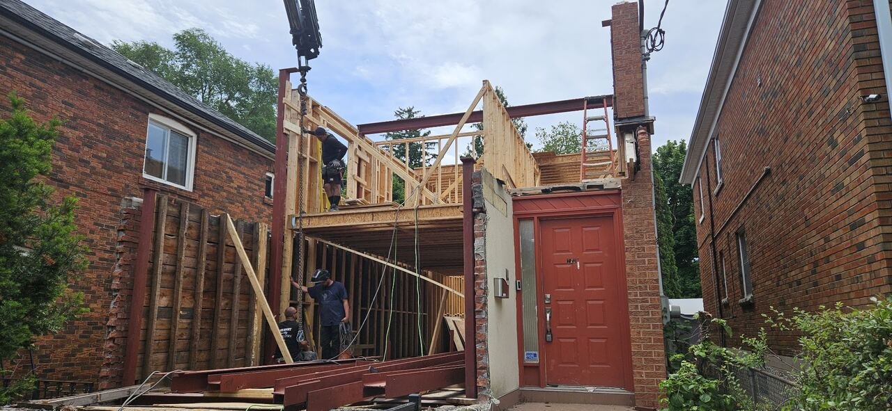 ALBO crew installing structural steel beams and framing at the front of the house