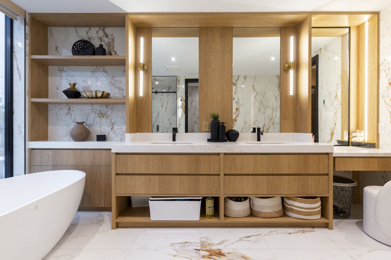 Primary ensuite with white oak double vanity, integrated storage baskets and a freestanding tub