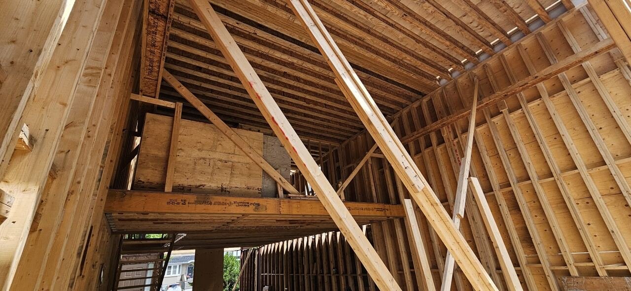 Interior view of the roof framing structure and engineered beams during construction