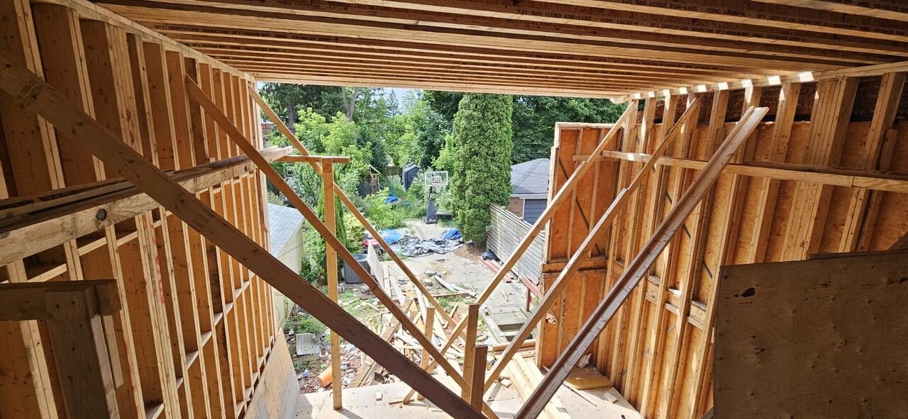 Second-storey framing with engineered floor joists looking out over the backyard