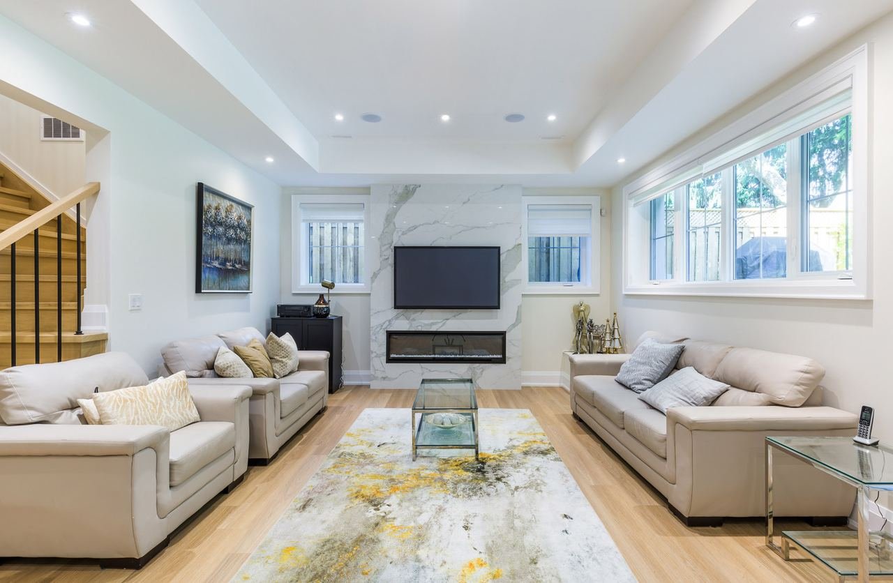 Basement living area with marble fireplace wall and walkout windows