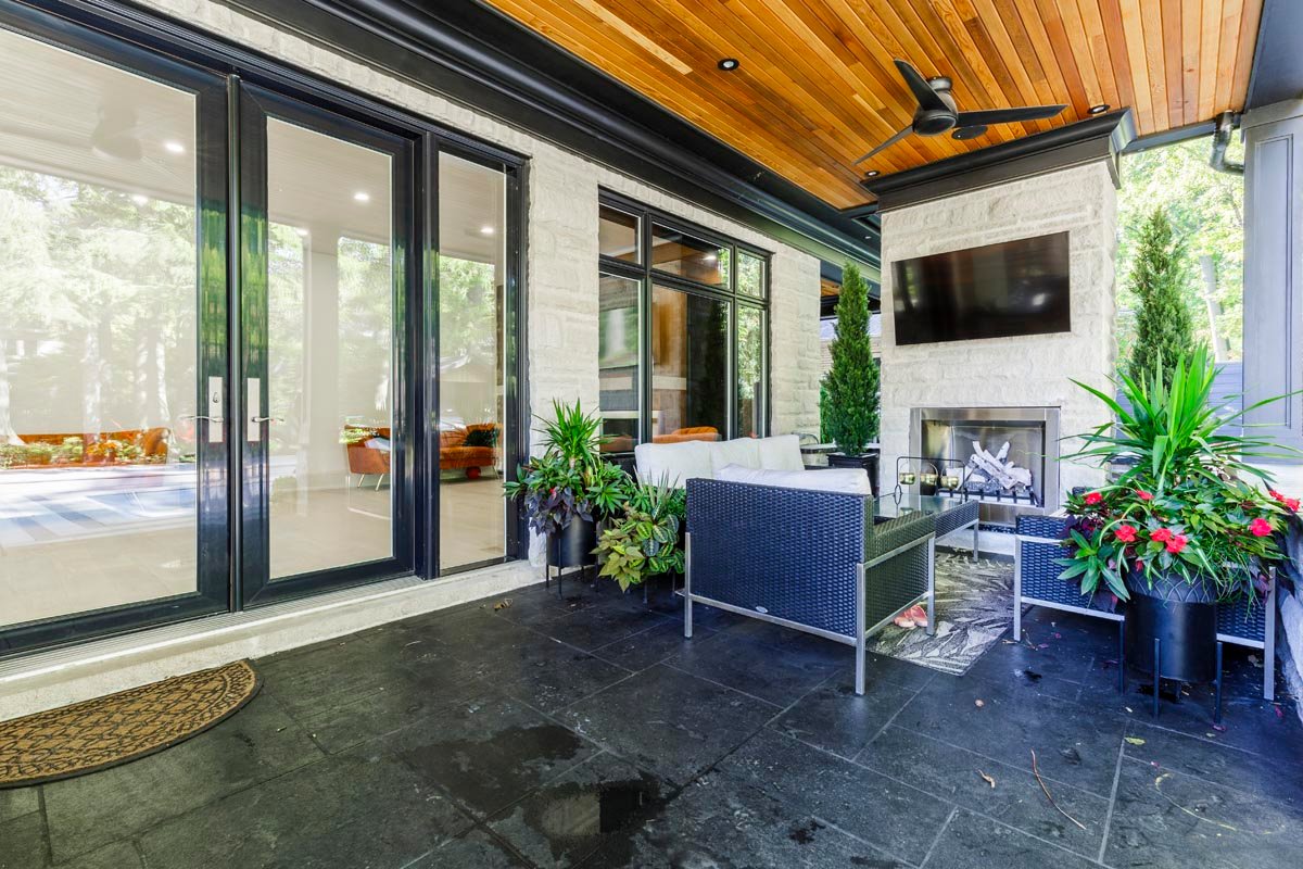 Covered patio with outdoor fireplace and TV