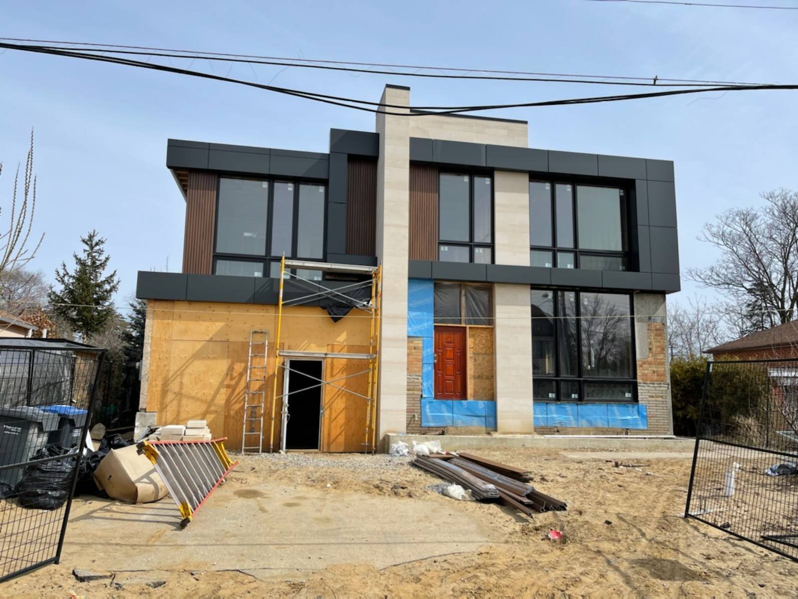 Exterior during construction with stone cladding and windows installed