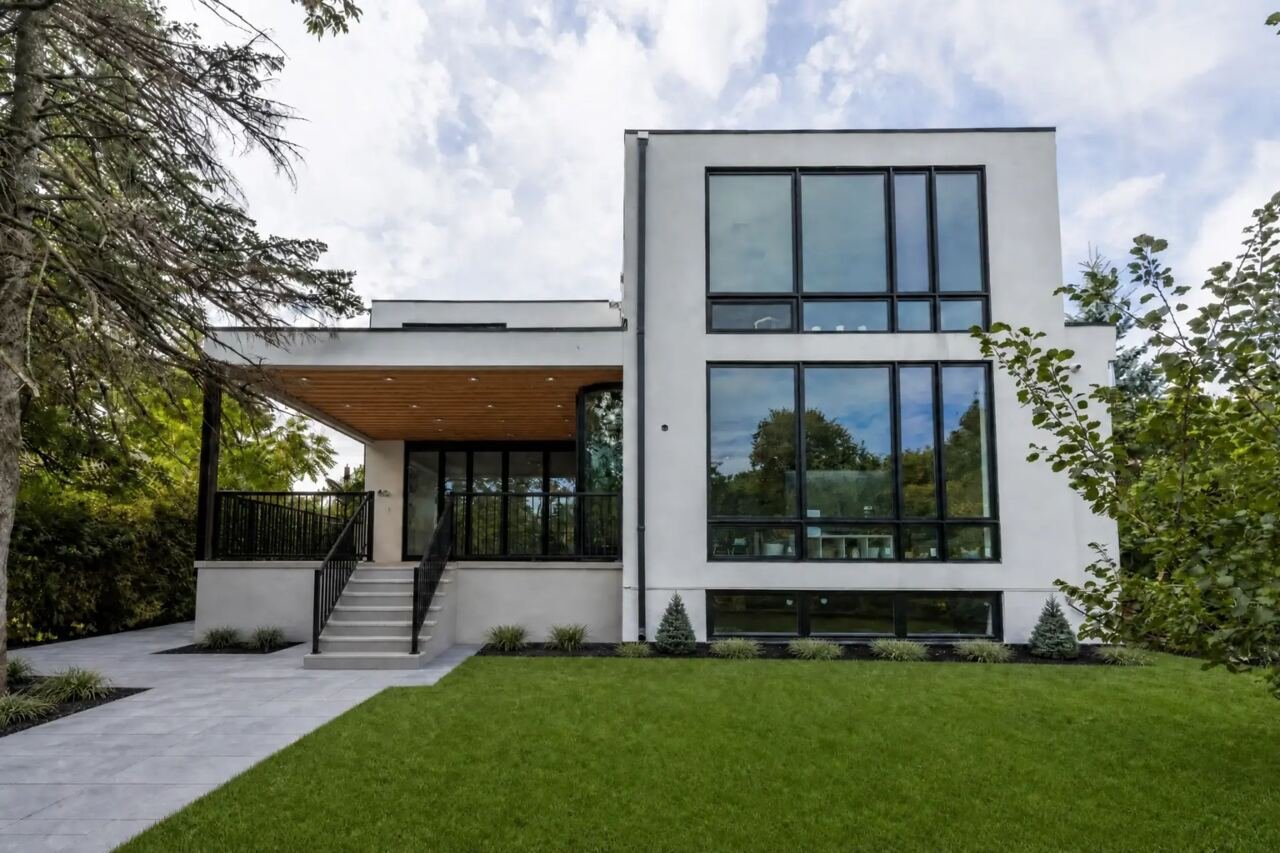 Rear elevation with covered patio, floor-to-ceiling windows and landscaped lawn