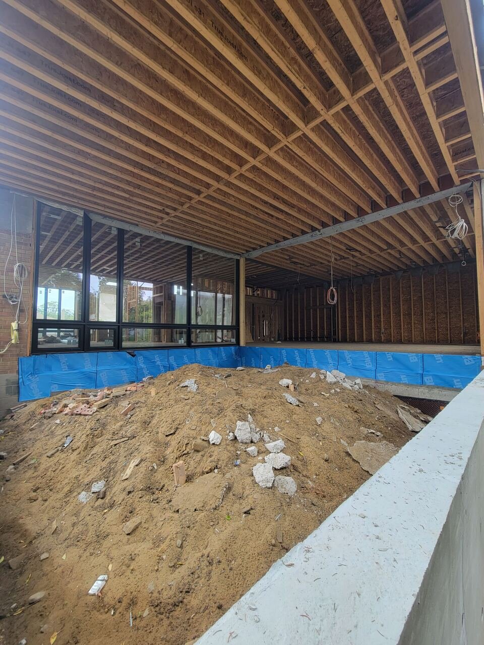 Rear of the home during framing with excavation and waterproofing in progress