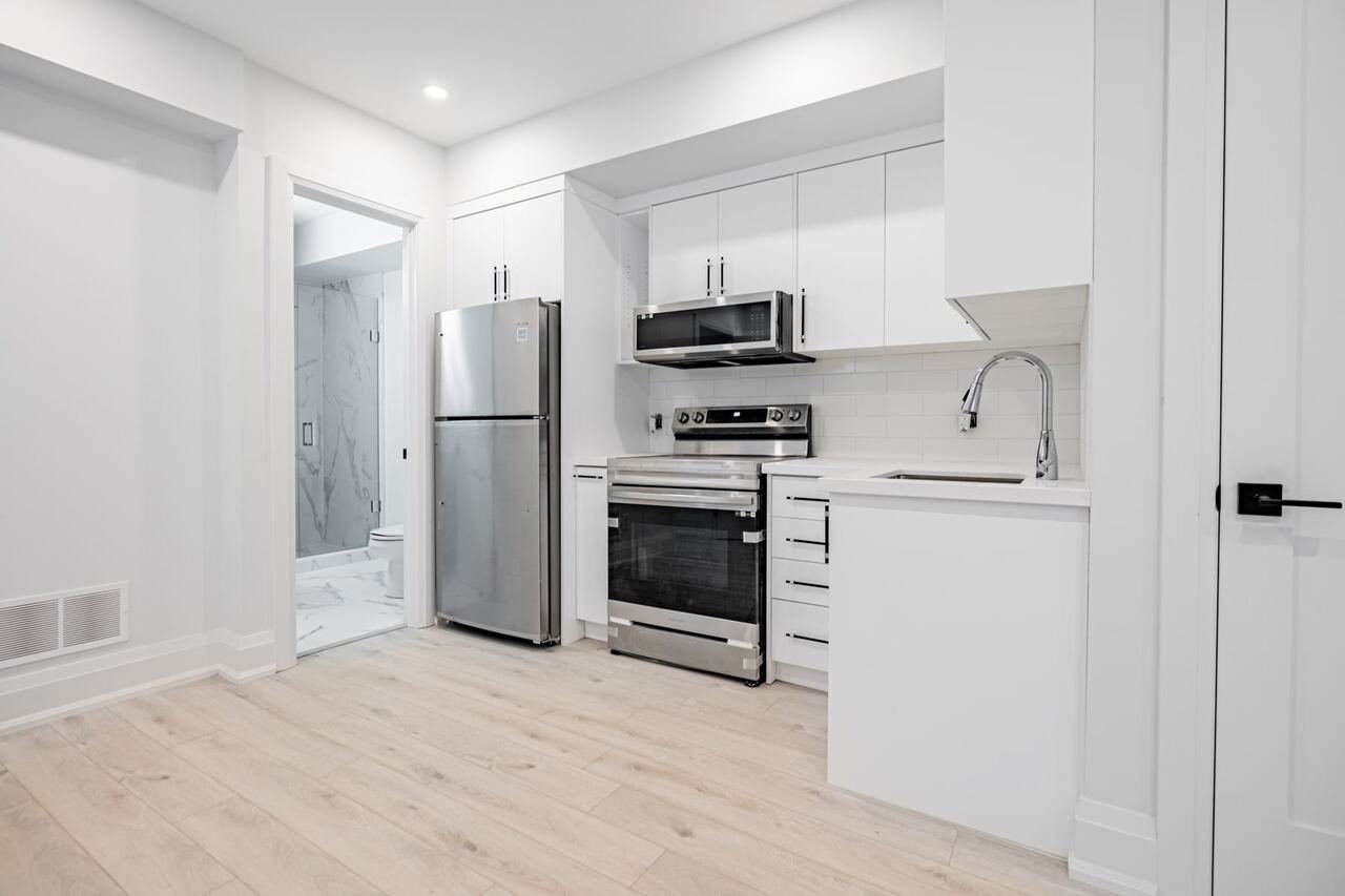 Basement suite kitchen with white cabinets and stainless appliances