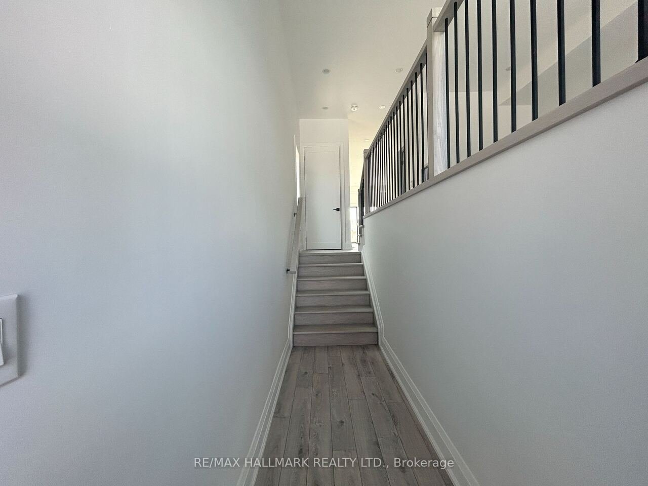 Staircase hallway with light oak treads and black metal spindles
