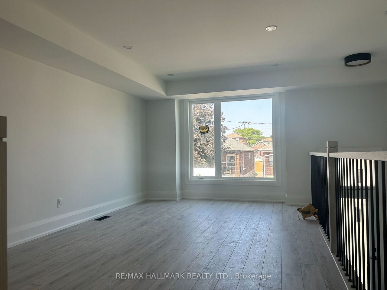Bright upper family room with large window and railing overlook