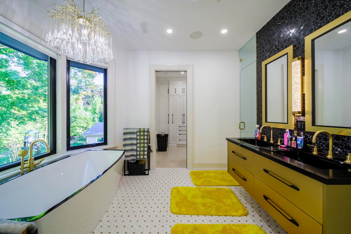Ensuite with black freestanding tub and gold vanities
