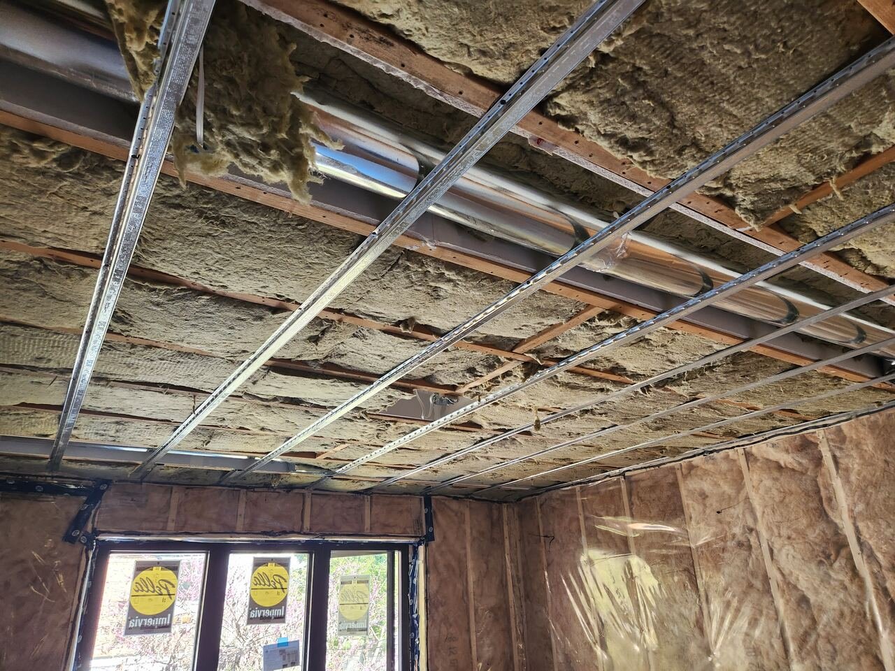Ceiling insulated with steel strapping and new plumbing lines run overhead