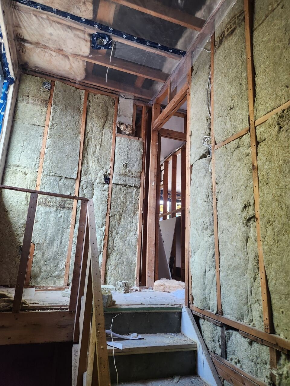 Stairwell walls insulated with mineral wool and vapour barrier installed