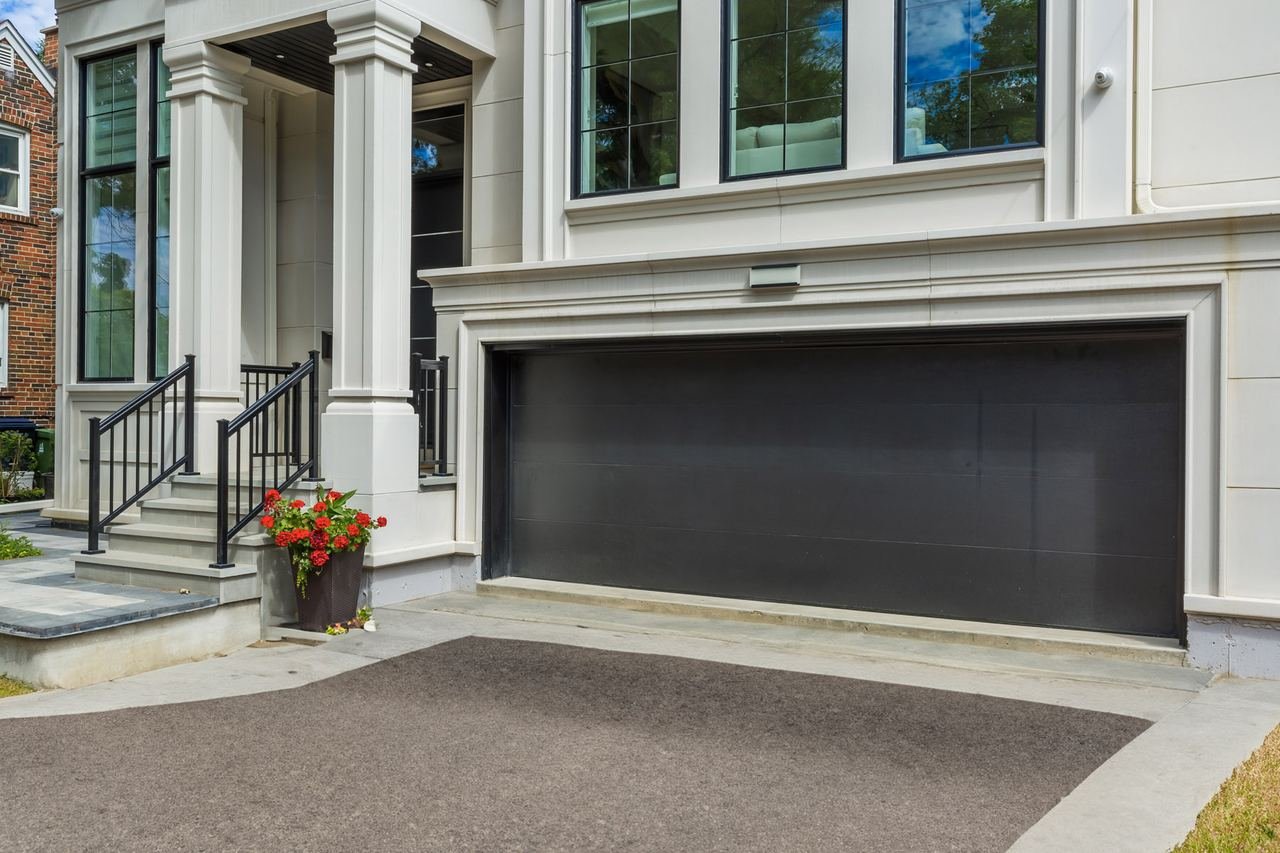 Front elevation with double car garage, stone steps and black railings