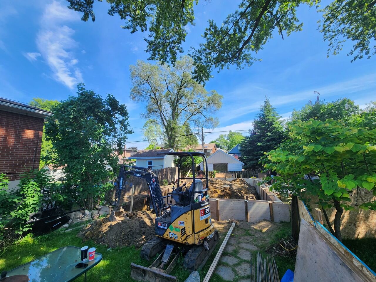 Mini excavator preparing the garden suite site behind the main house