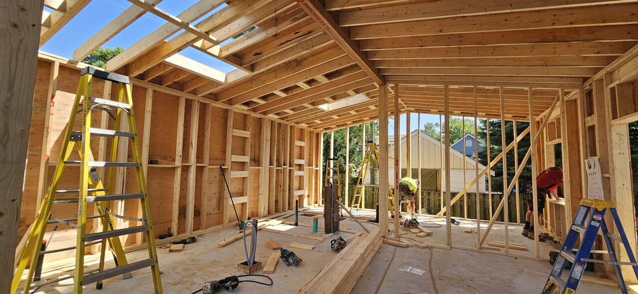 Garden suite interior during framing with roof joists and skylight openings
