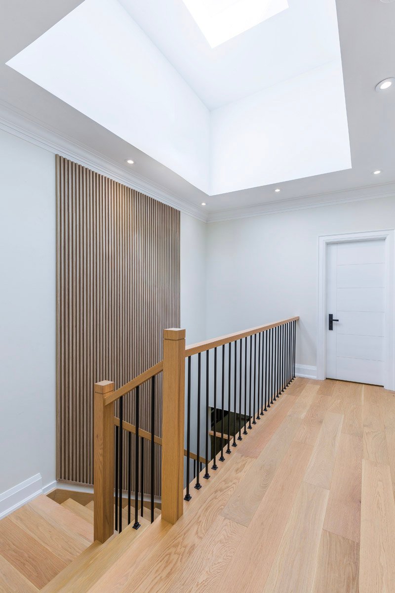 Upper hallway with skylight, wood slat wall and white oak flooring